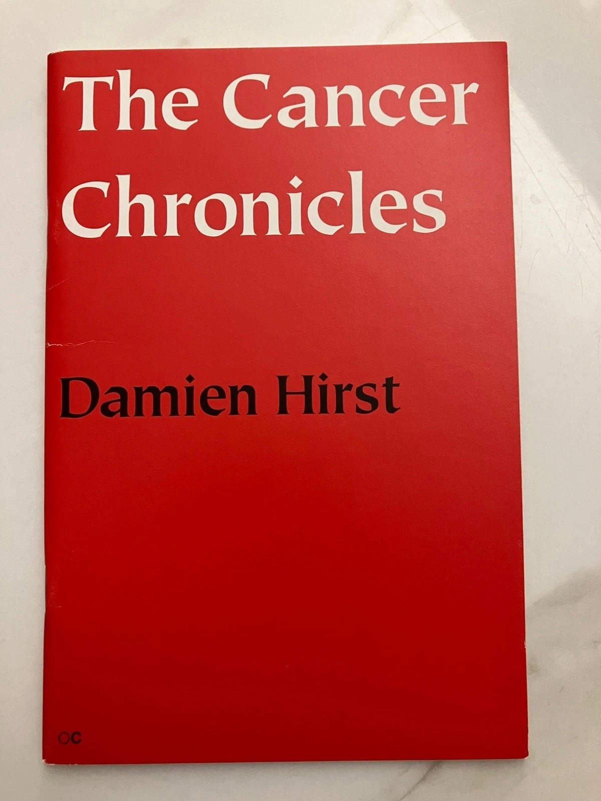 Self portrait by Damien Hirst featuring a colorful smiley face design on a textured background.